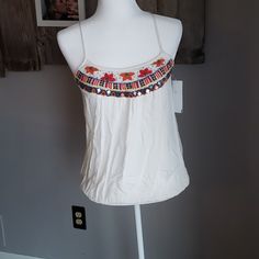 Raga Tank Top. Pretty Embroidery And Beadwork At Top, Spaghetti Straps That Come To A T In Back With Embroidery Details Elastic At Waist Embellished Embroidered Top For Summer, White Beaded Top For Summer, Summer Embellished Embroidered Top, Summer White Beaded Top, Spring Beaded Multicolor Tops, White Beaded Bohemian Tops, Summer Embellished Multicolor Embroidered Top, White Sleeveless Embroidered Festival Top, Spring Embroidered Spaghetti Strap Tank Top