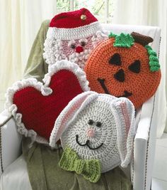 three crocheted pumpkins are sitting on a chair