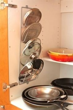 pots and pans are stacked on the wall in this kitchen cabinet with text overlay that reads pot lid rack