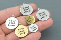 hand holding five personalized pet tags with your text here in gold, silver or bronze