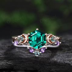 an emerald colored ring with three stone accents