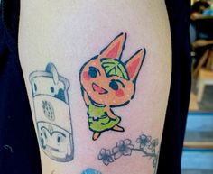 a person with a tattoo on their arm has a cartoon character next to a cell phone