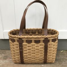 a brown and tan basket sitting on top of a wooden floor