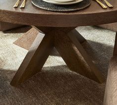 a wooden table with plates and silverware on it