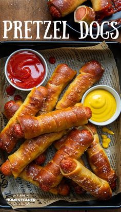 two trays filled with pretzel dogs and ketchup on the side