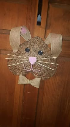 a rat made out of straw sticks with a bow tie on it's head