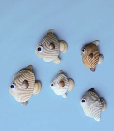 five small fish made out of seashells on a blue surface