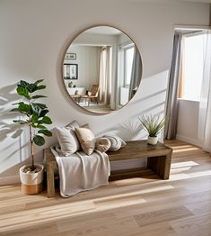 a living room with a couch, mirror and potted plant