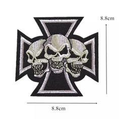 an iron cross with two skulls on the front and one skull on the back, in white