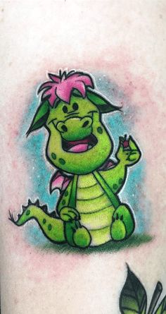 a green cartoon character sitting on top of a person's leg with pink hair