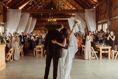 a bride and groom sharing their first dance in front of an audience at a wedding