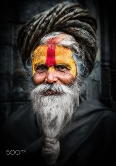 an old man with his face painted yellow and red