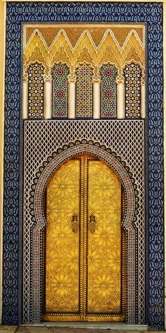 an ornate door in the middle of a building with gold and blue tiles on it