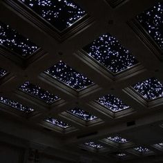 the ceiling is lit up with blue lights and stars on it's glass panels