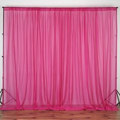 a pink curtain is hanging over a wooden floor