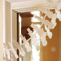 snowflakes hanging from the side of a window sill in front of a mirror