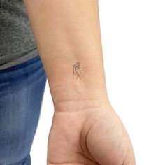 a woman's arm with a small tattoo on the left side of her wrist