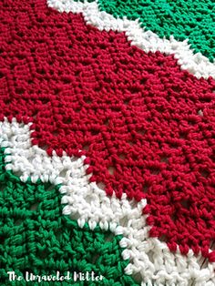 a crocheted afghan with red, white and green colors on it's edges