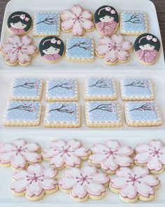 some decorated cookies are sitting on a white platter with pink and blue flowers in the middle