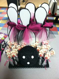 a table topped with candy and candies next to a black bag filled with white chocolates