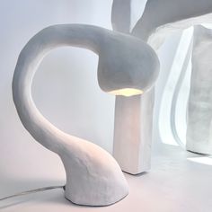 a large white sculpture sitting next to a lamp