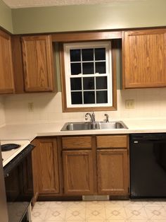 an empty kitchen with wooden cabinets and black appliances