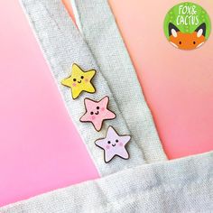 three little stars are on the back of a tote bag with a pink background