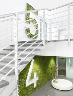 there is a white staircase with moss growing on the wall and numbers painted on it