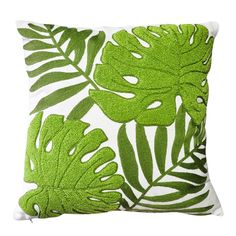 a green and white pillow with leaves on it