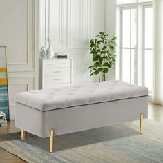 a white bench sitting on top of a rug in a living room next to a potted plant