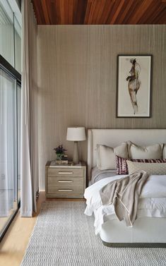 a bedroom with a bed, dresser and window in front of the sliding glass door