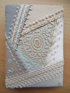 a close up of a piece of cloth on a wooden table with beads and pearls