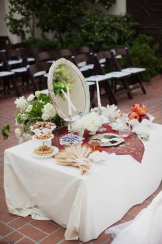 the table is set up with flowers and mirrors