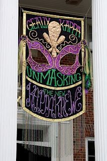 a mardi gras sign hanging from the side of a building