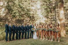 a group of people standing next to each other in front of trees