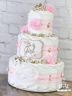 a three tiered wedding cake with pink flowers on the top and gold trimmings