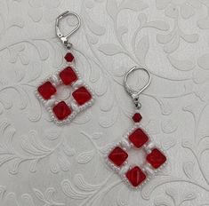 Beautiful red and white silky bead bead woven earrings. Red silky beads, white super duos and white seed beads, all woven together and finished on lever back ear wires.  If you would like a different type of ear wire, please notify me and I can customize it for you. Ready to ship.  Fashioned using the Silky Squares  pattern from Deb Roberti (Around the Beading Table) Attention! Colors may look different depending on your monitor settings. Jewelry Care:  To keep the materials in your jewelry in good condition, do not wear while swimming, bathing, or heavily exercising. Avoid contact with abrasive or sharp objects, water, oils, lotions, perfume, chemicals, and excessive perspiration, as these things may alter bead finishes or cause damage to the materials in your jewelry. Woven Earrings, Spider Web Decoration, Quilted Ornaments, Super Duo, Sharp Objects, Square Bead, Earrings Red, Quilted Wall Hangings, Square Pattern