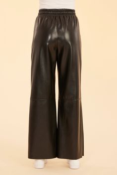 Our Faux Leather Wide Leg Drawstring Pants are perfect for adding some edge to your cozy fall wardrobe. Crafted from luxurious faux leather, these pants feature a wide-leg silhouette and a thick drawstring waistband for a chic and comfortable fit. Pair it with your favorite sweater for a laid-back outfit or throw on a sleek blazer for a more polished look. Faux leather Drawstring waistband Wide leg Available in Camel and Black Dry clean Style: 75510 Fall Leather Wide Leg Pants, Leather Wide Leg Pants For Fall, Fall Wide Leg Faux Leather Pants, Chic Wide Leg Leather Pants, Chic Wide-leg Leather Pants, Chic Leather Wide-leg Pants, Sleek Wide-leg Leather Pants, Sleek Wide-leg Leather Pants For Fall, Sleek Black Wide-leg Leather Pants