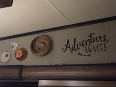 there is a sign that says adventure awaits on the wall