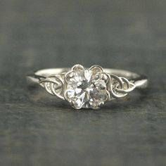 a white gold engagement ring with an old - fashioned design and a round diamond center