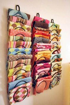 a wall hanging organizer filled with lots of colorful fabric