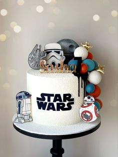 a star wars themed birthday cake with toys on the top and decorations around it,