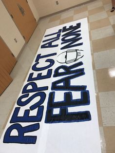 a large sign that is on the ground in a room with tile flooring and walls