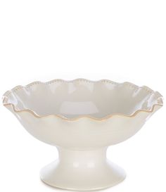 a large white bowl with scalloped edges on a stand against a white background