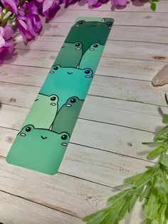 a green skateboard sitting on top of a wooden floor next to purple flowers and greenery