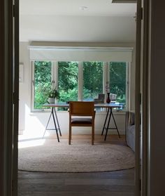 an open door leading to a living room with a desk and chair in it,