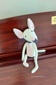 a crocheted toy mouse sitting on top of a wooden piano with the words ball terrier written above it