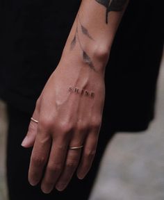 a person with a tattoo on their arm holding onto the wrist that reads, shine