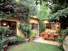 an outdoor dining area with table, chairs and potted plants