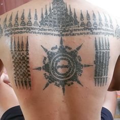 the back of a man with tattoos on his upper and lower part of his body